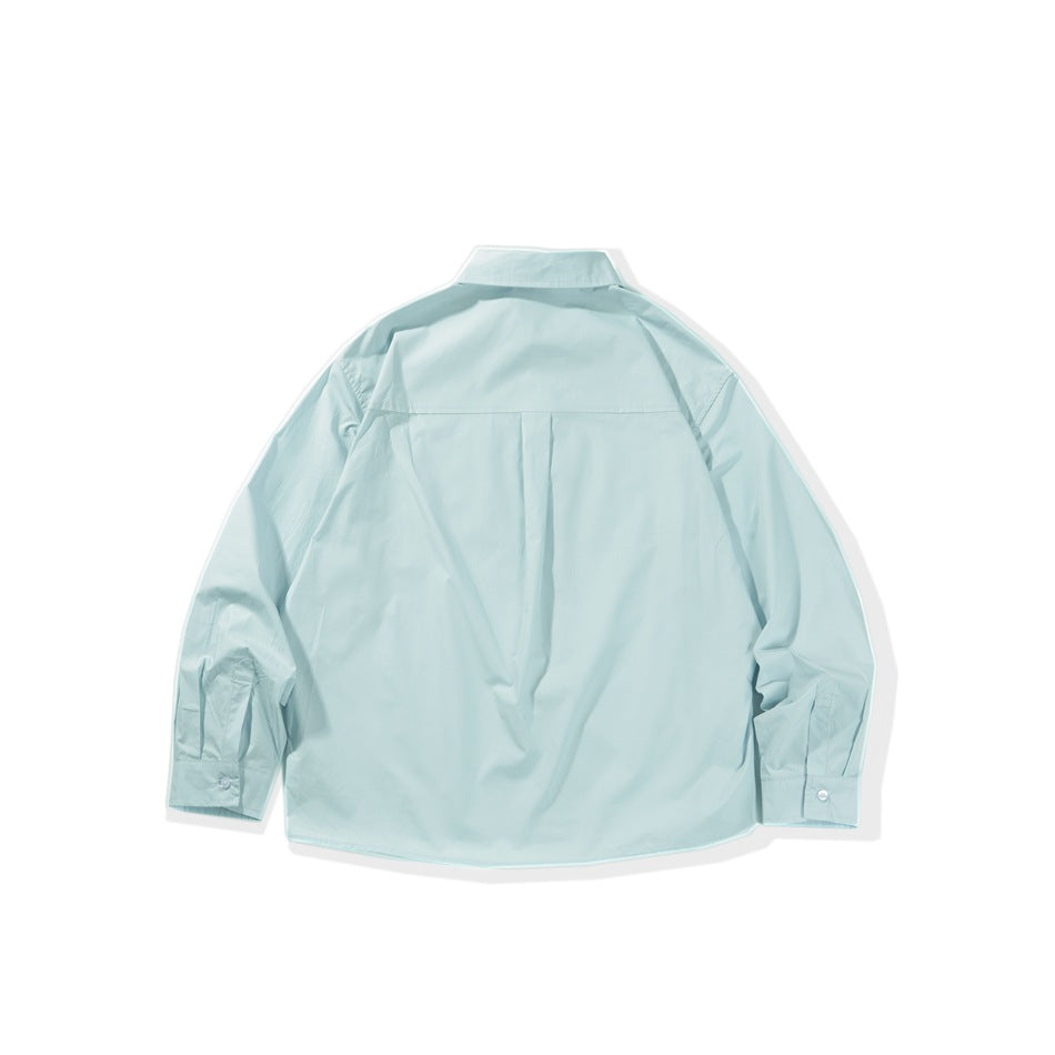 Back view of a pale aqua long-sleeve button-up shirt with a center pleat and button cuffs on white.