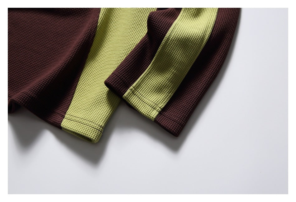 Close-up of burgundy and chartreuse waffle-knit sleeves with stitched cuffs.