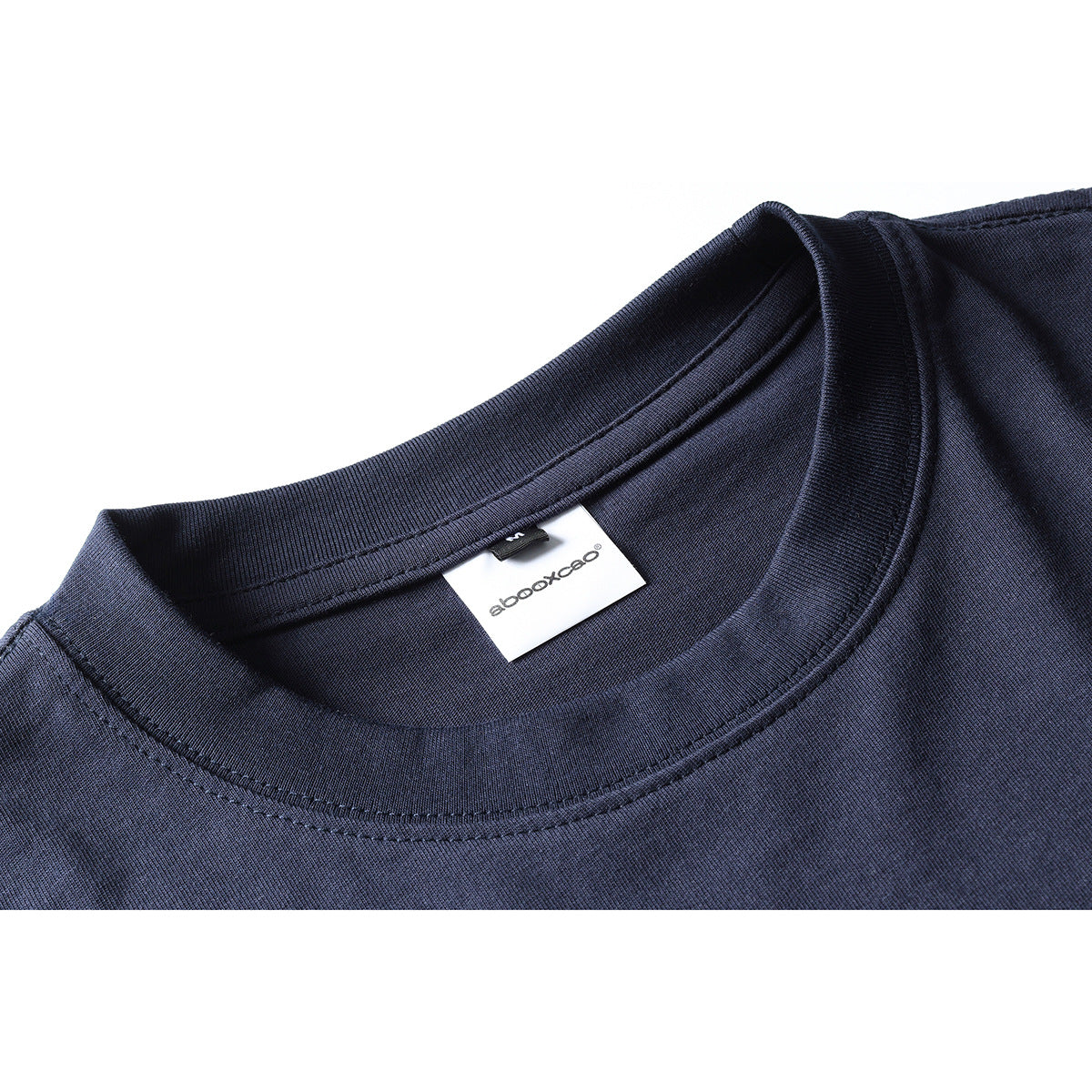 Close-up of a navy T-shirt's ribbed crew neck, stitching, and inner brand label.