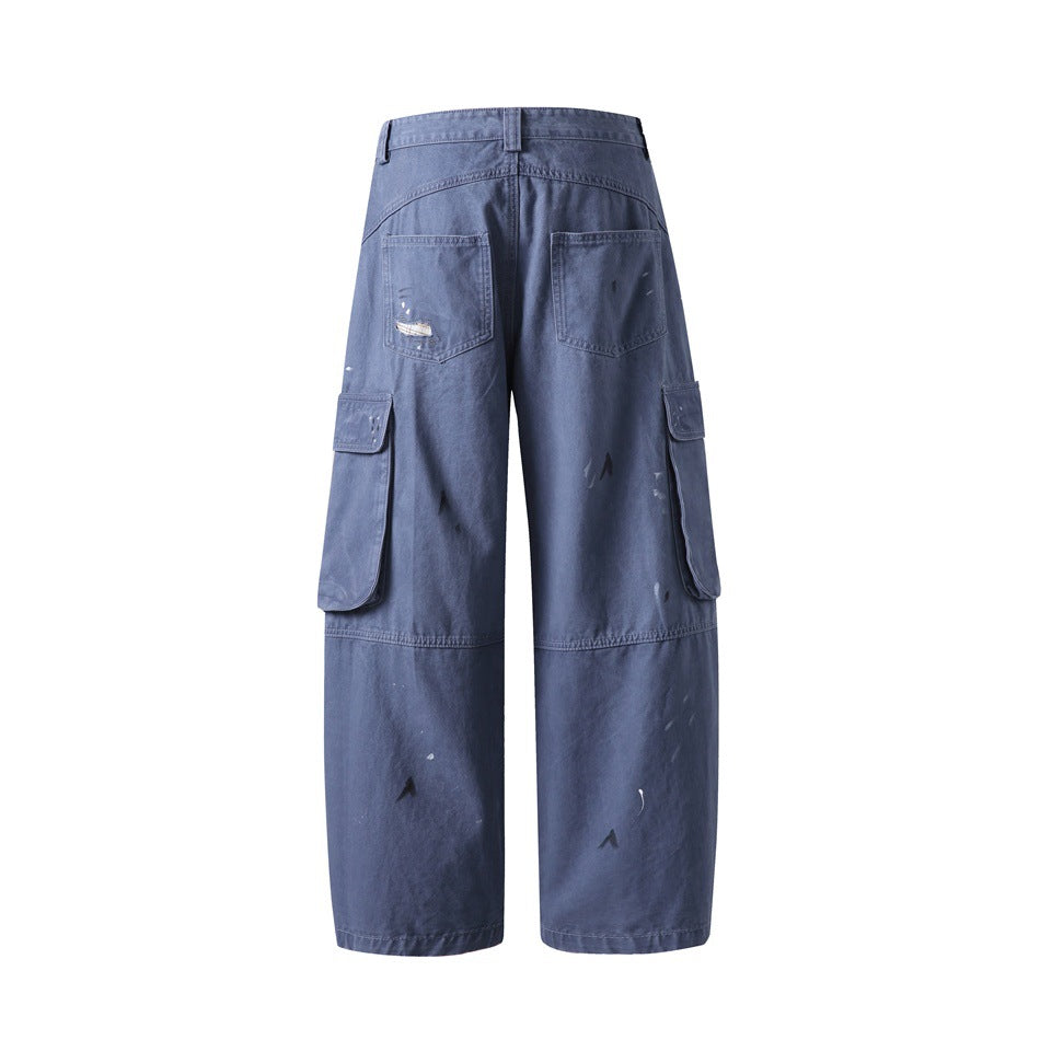 Rear view of wide-leg blue-gray cargo pants with two back pockets, side cargo pockets, and scattered distressed marks.