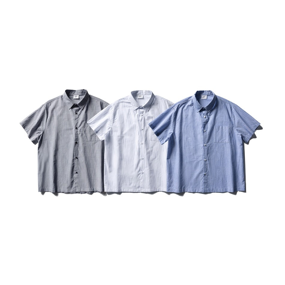 Three short-sleeve button-up shirts arranged front-facing in gray, white, and blue, each with a chest pocket.