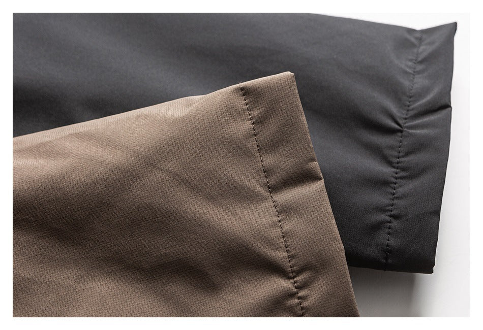 Close-up comparing brown textured jacket fabric with a dark cuff or fabric panel.