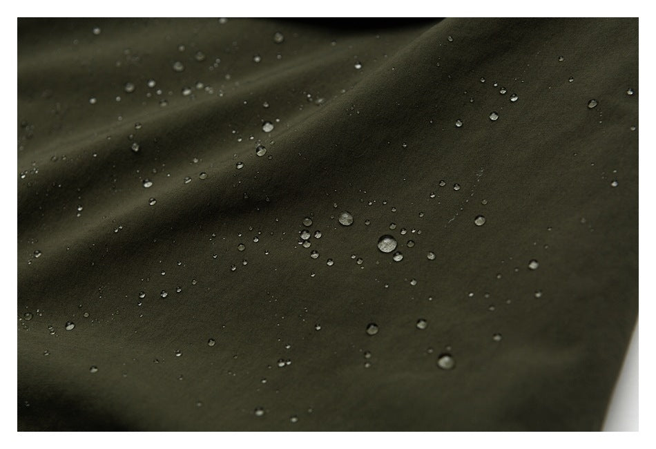 Water droplets bead on dark olive fabric in a close-up view.