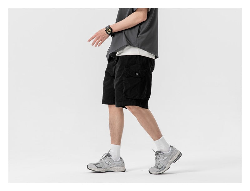 Model in black cargo shorts with a large flap pocket, shown walking in side view.