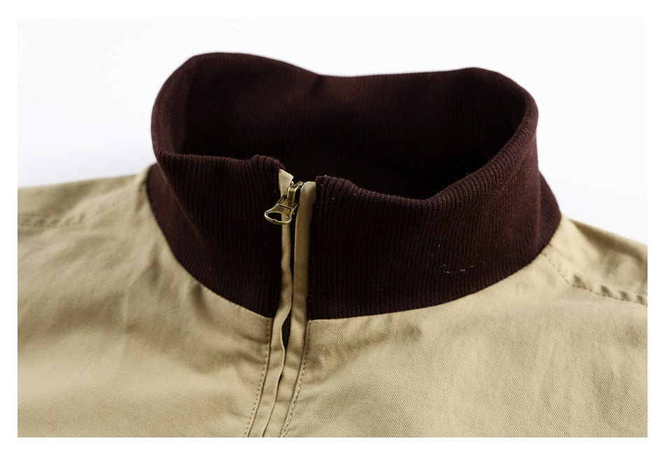 Close-up of a khaki jacket with a raised dark brown ribbed collar and front zipper.