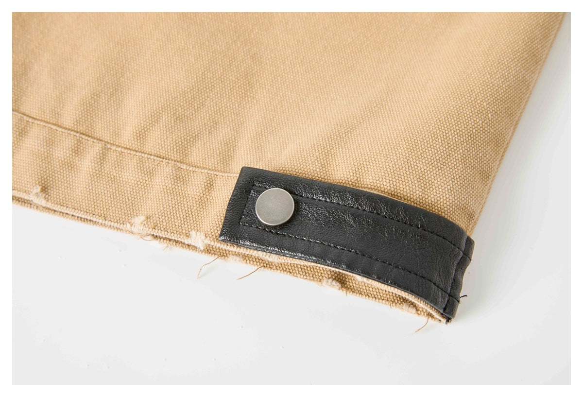 Tan woven garment edge with a black snap-fastened tab.