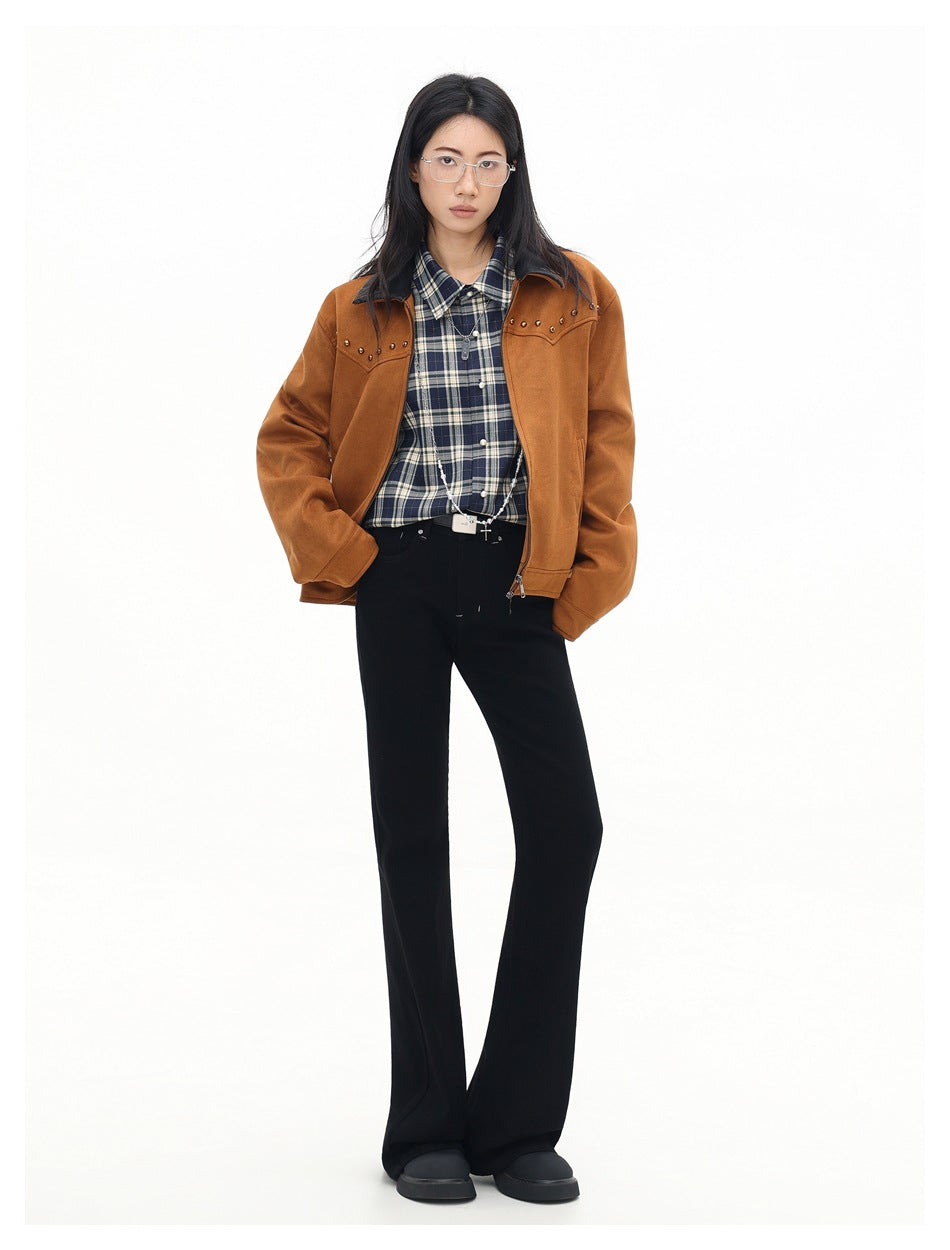 Full-length model wearing a rust-brown studded jacket, navy plaid shirt, and black flared trousers.