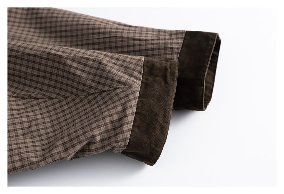 Close-up of plaid jacket sleeves with contrasting dark brown cuffs.
