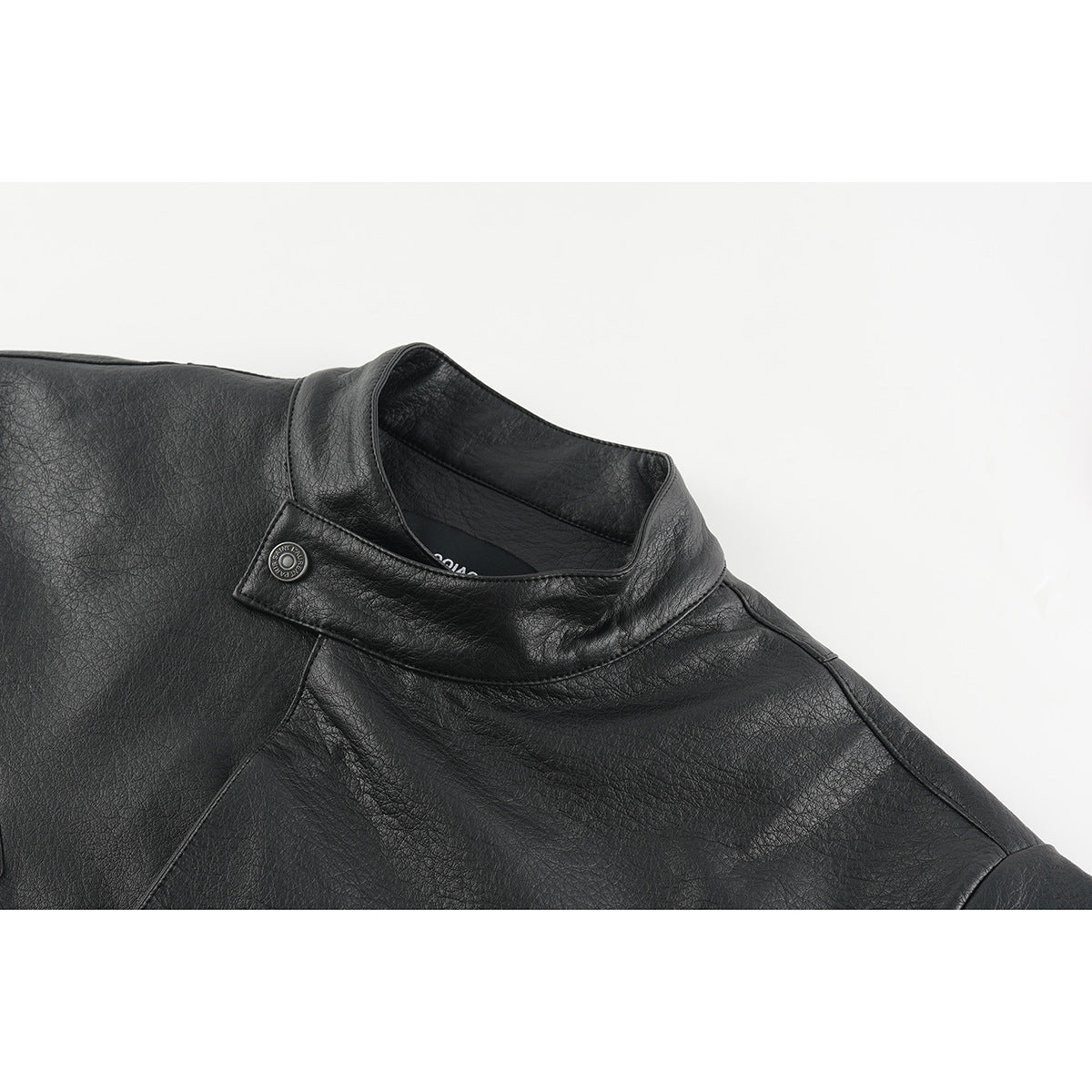 Close-up of a black jacket's stand collar, shoulder seams and snap tab.