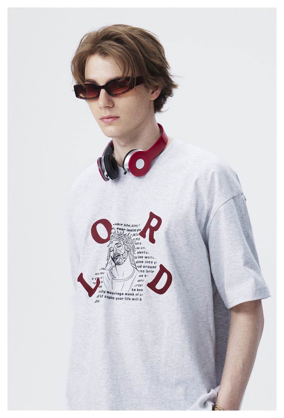 Close view of a model wearing a light gray T-shirt with burgundy lettering and a central illustrated print.