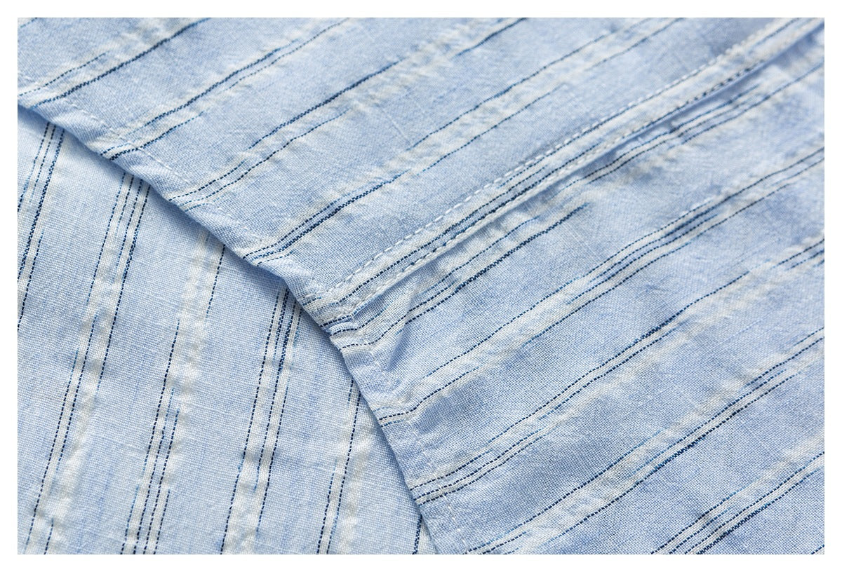 Overlapping pale blue striped fabric shows fine texture and rows of dark stitching.