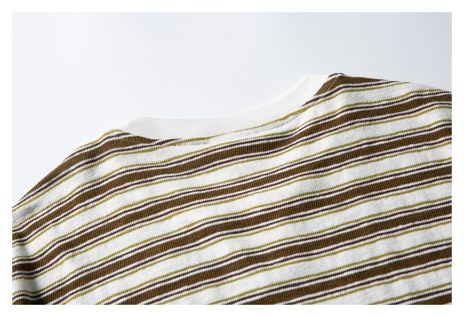 Partial back view of a cream shirt with brown and olive horizontal stripes and a plain ribbed crew neckline.