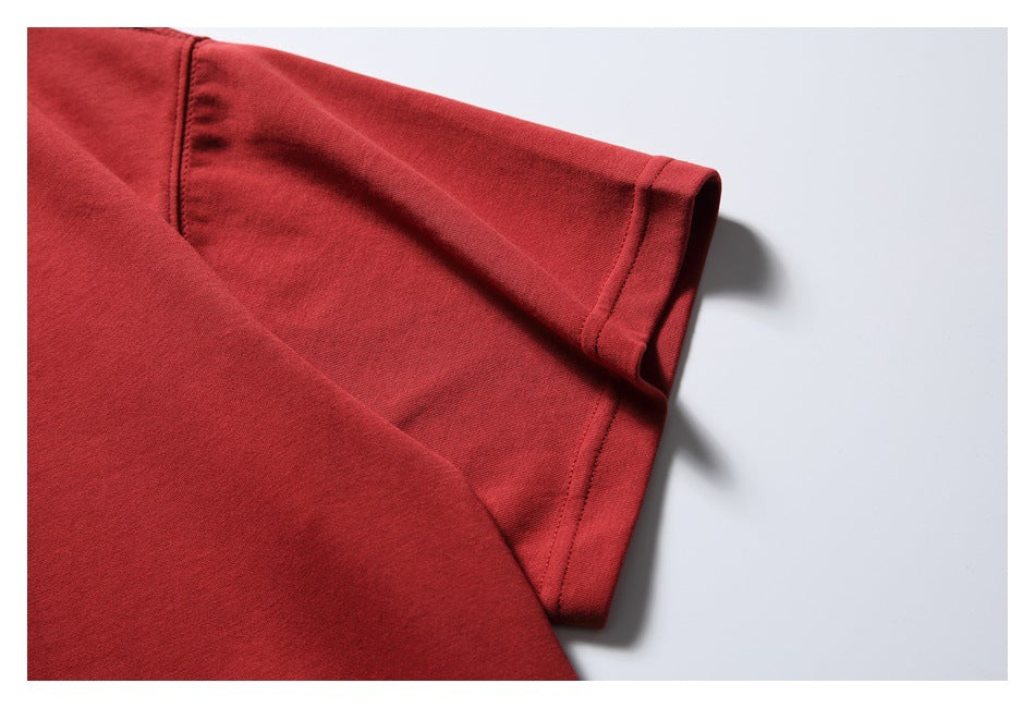 Close-up of a red T-shirt sleeve and shoulder seam with a stitched sleeve hem.