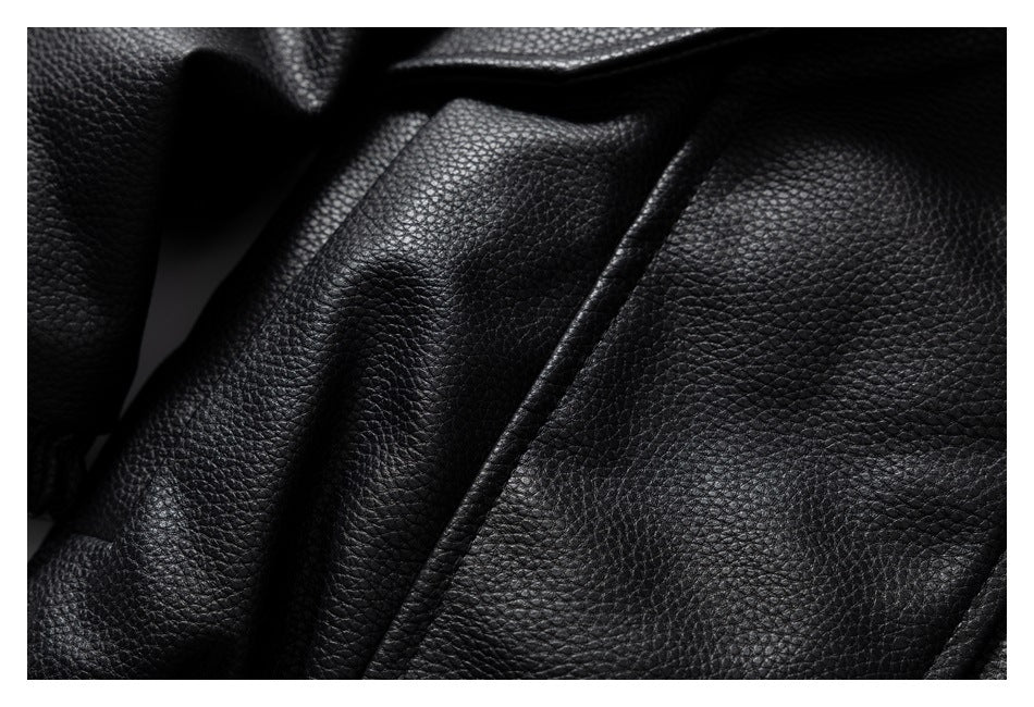 Extreme close-up of the black jacket's pebbled surface and stitched panel seam.