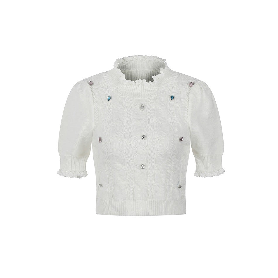 Off-white cropped short-sleeve cable-knit top with ruffled neckline, puff sleeves and colorful gem accents