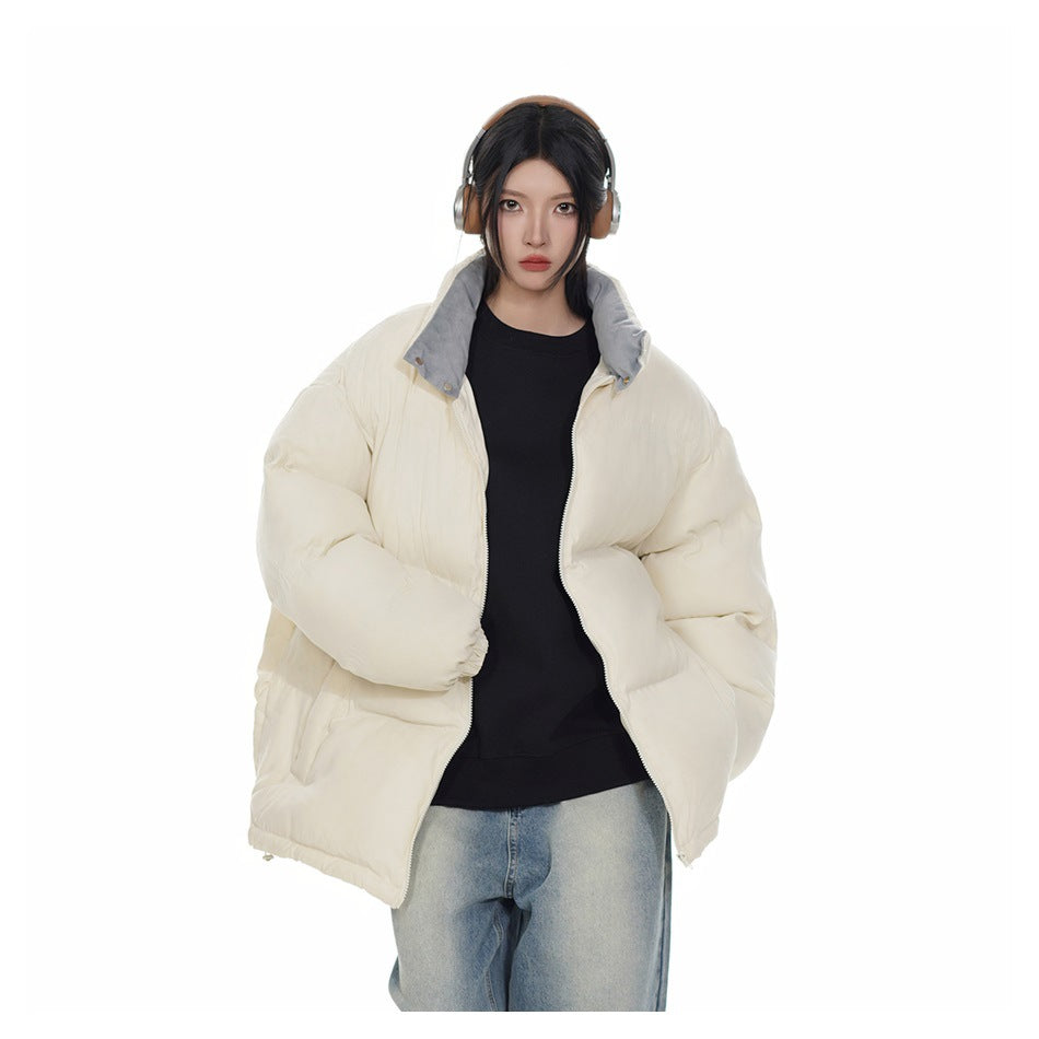 Model wearing an open beige puffer jacket with gray inner collar over a black top and light-wash jeans
