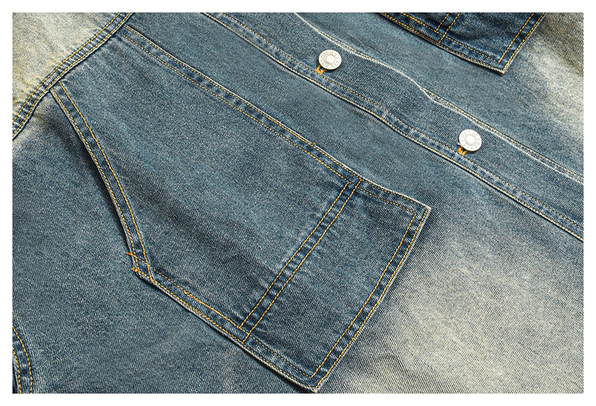 Close-up of the jacket’s front pocket and button placket, showing blue denim panels and contrasting yellow stitching.