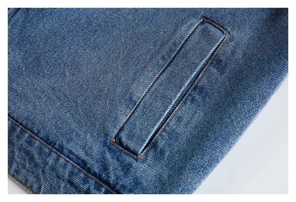 Close-up of a narrow stitched denim loop or tab against blue denim.