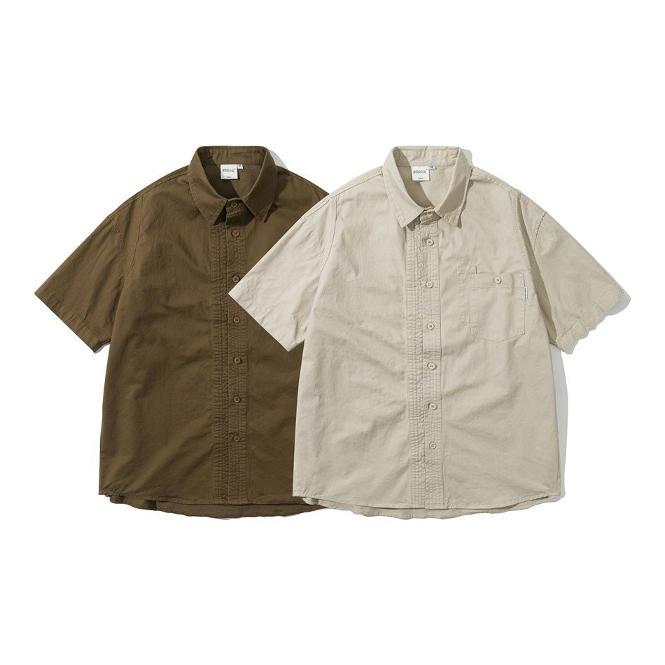 Two short-sleeve button-up shirts shown from the front: dark olive and light beige, each with a chest pocket.