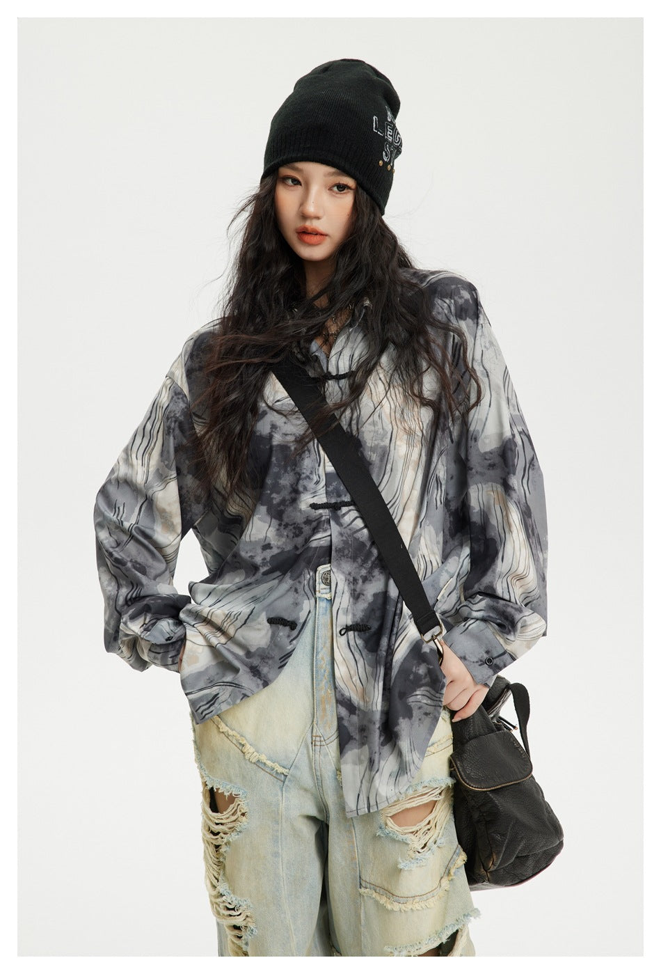 Model wearing an oversized gray abstract-print shirt with black frog closures, shown from the front.