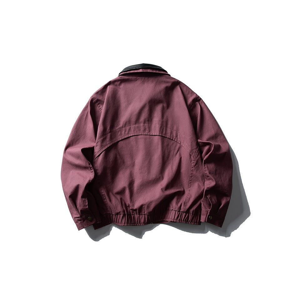 Back view of a burgundy jacket with a black collar, curved back yoke, and gathered hem.