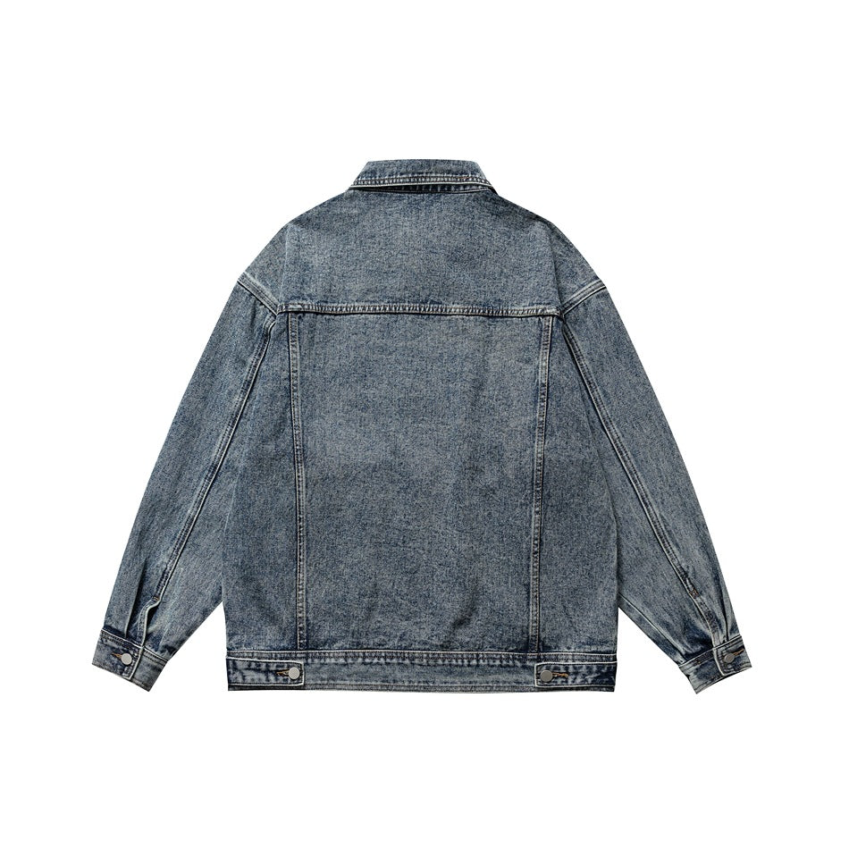 Back view of blue washed denim jacket showing yoke seam, panel seams, cuff buttons and waistband tabs