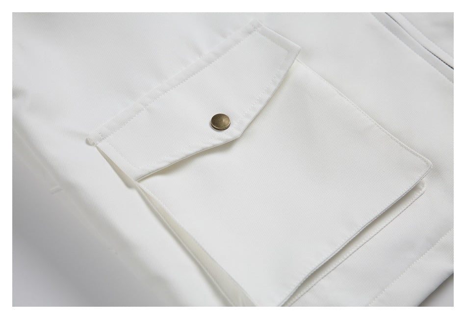 Close-up of a white garment pocket flap with a bronze-tone snap button.