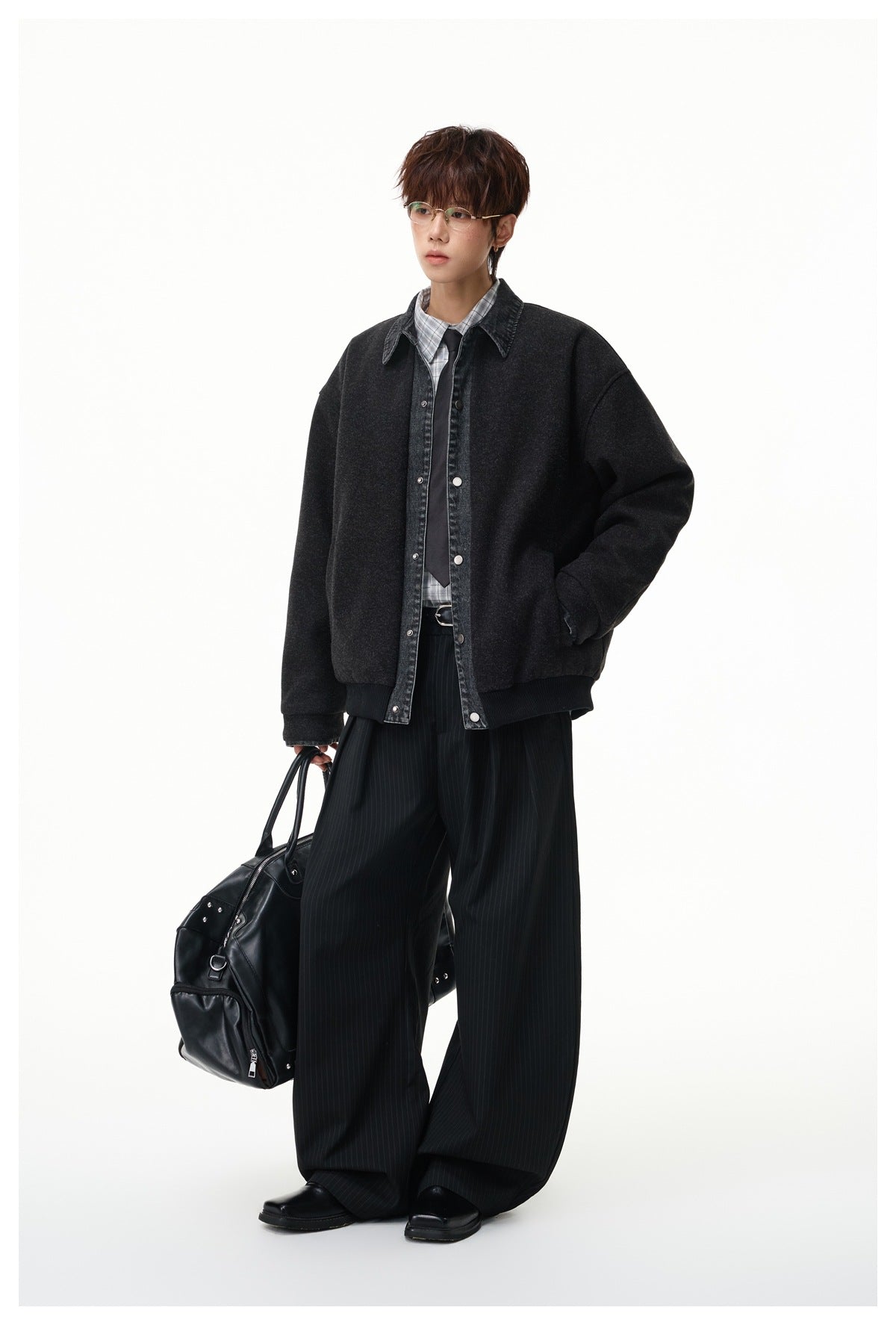 Full-length model wearing a dark charcoal jacket with a washed denim collar and snap front.
