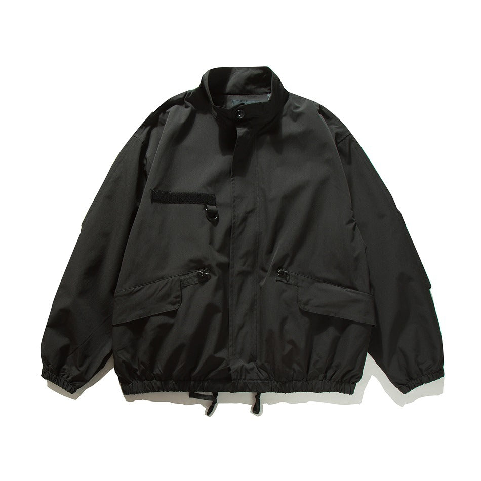 Black stand-collar bomber-style jacket, flat front view with chest patch, flap pockets and elastic hem