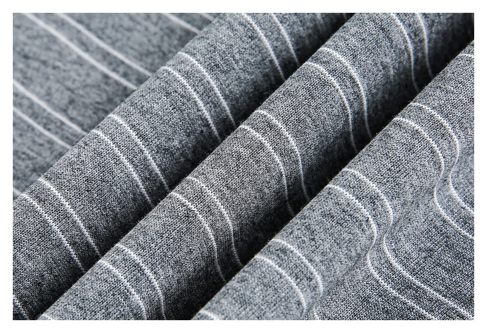 Close-up of folded gray heathered fabric with thin white stripes, showing its knit texture.