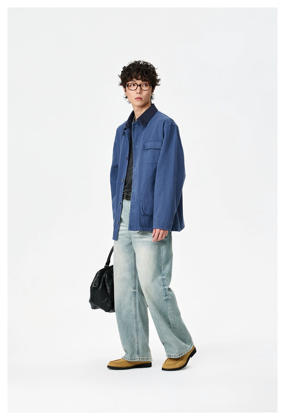 Model in a blue button-front work jacket with a dark collar and chest pocket, paired with light-wash jeans.