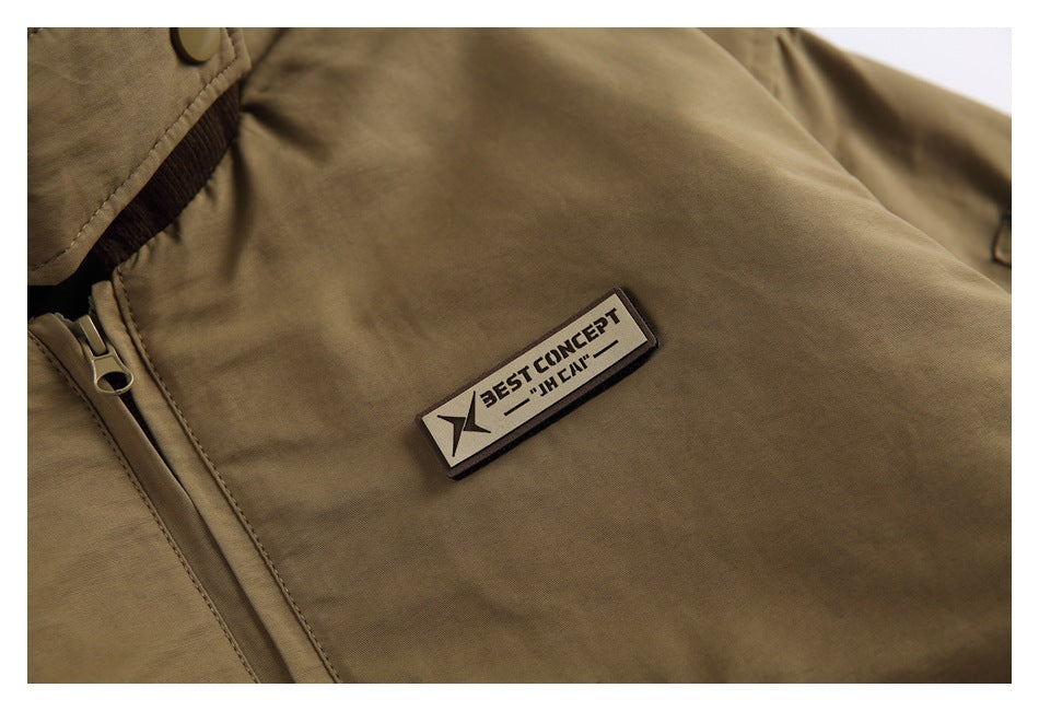 Close-up of an olive-brown jacket chest with a zipper and a small rectangular BEST CONCEPT patch.