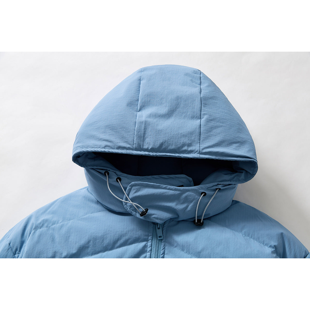 Close-up of a light blue hooded jacket showing the hood, drawcords, and upper front zipper.