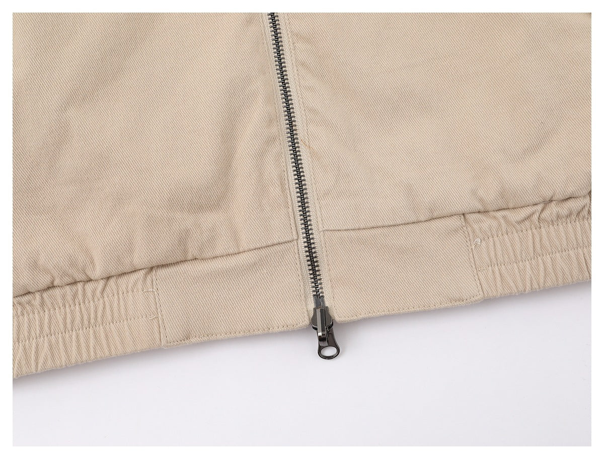Close-up of the beige jacket's front zipper and gathered elastic waistband.