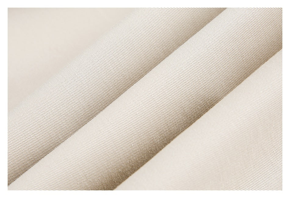 Close-up of light beige fabric folds showing a fine diagonal weave texture.