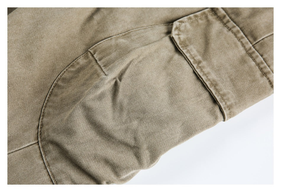 Close-up of taupe trouser fabric and curved seam construction near the leg opening.