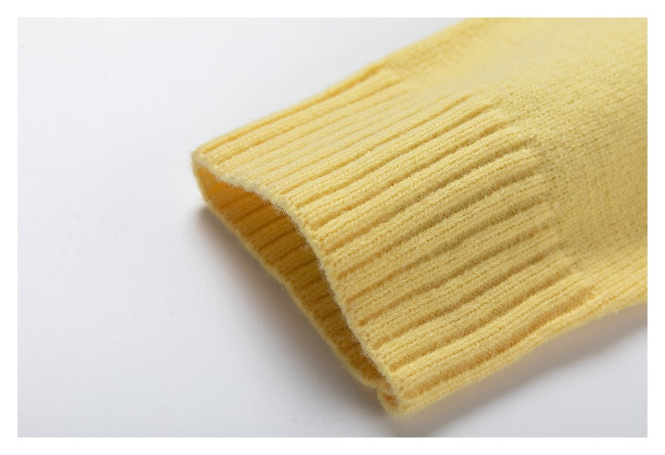 Close-up of a pale yellow sweater sleeve ending in a wide ribbed cuff.