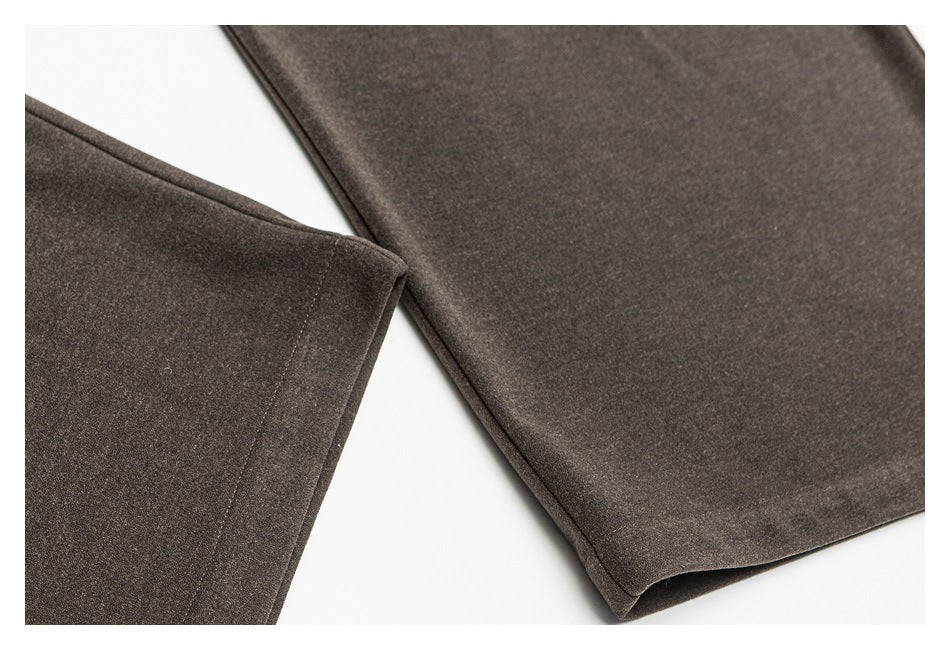 Close-up of dark brown trouser legs and stitched hems laid against a white background.