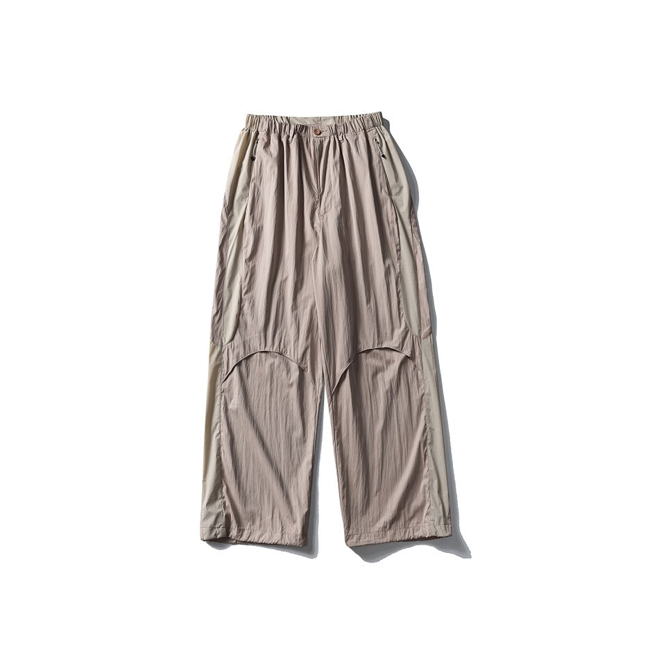 Front view of taupe wide-leg trousers with an elastic waist and curved panel seams.