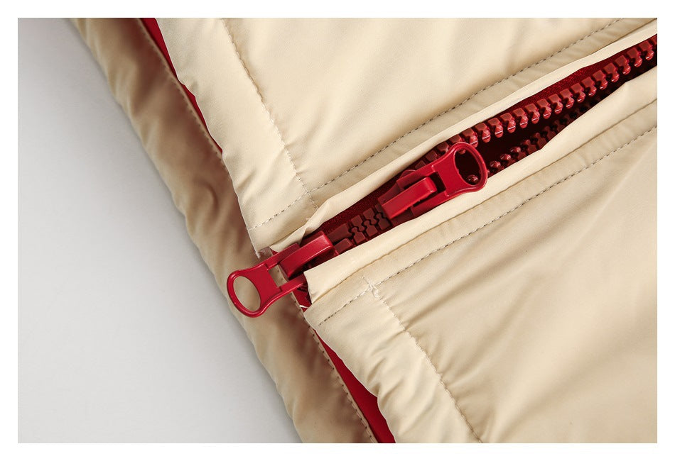 Close-up of a bright red zipper with two sliders on a cream garment.