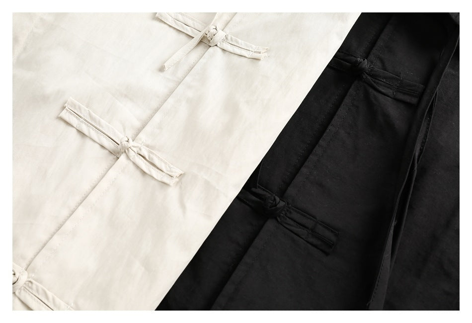 Close-up of cream and black shirt fronts with traditional knotted frog closures.