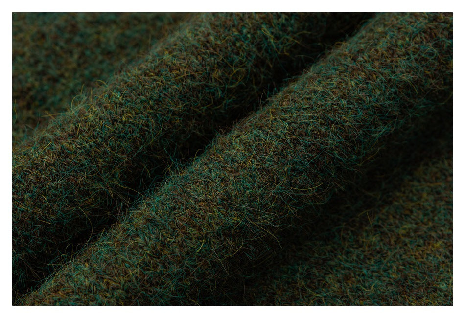 Extreme close-up showing the thick, fuzzy mottled teal-brown knit and a raised edge.