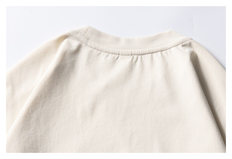 Cropped rear view of a plain cream crewneck sweatshirt, showing the ribbed neckline and shoulders.