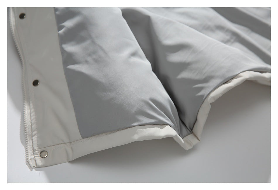 Close-up of a white and light gray jacket hem and sleeve area with snap fasteners.