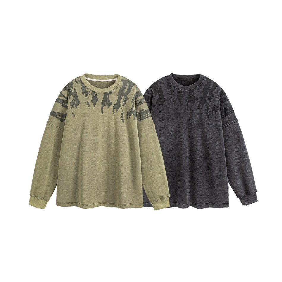 Two front views of the same long-sleeve sweatshirt in khaki and charcoal, both with dark abstract shoulder graphics.