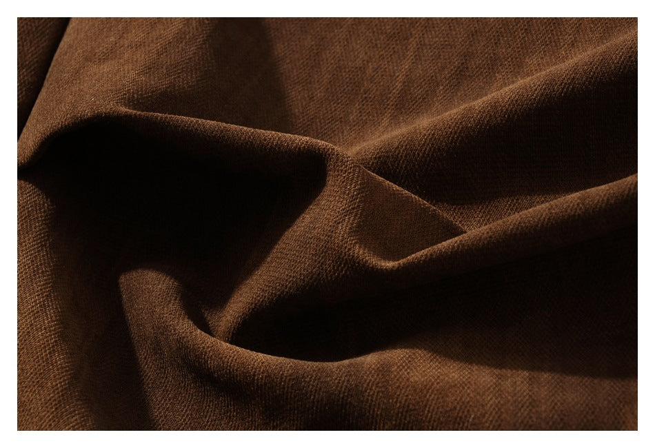 Macro view of the textured dark brown fabric in deep folds.