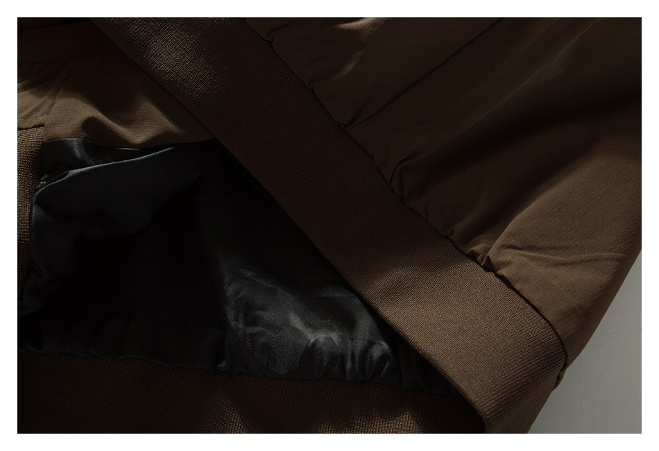 Close-up of a brown garment’s black inner lining and wide elastic hem band.