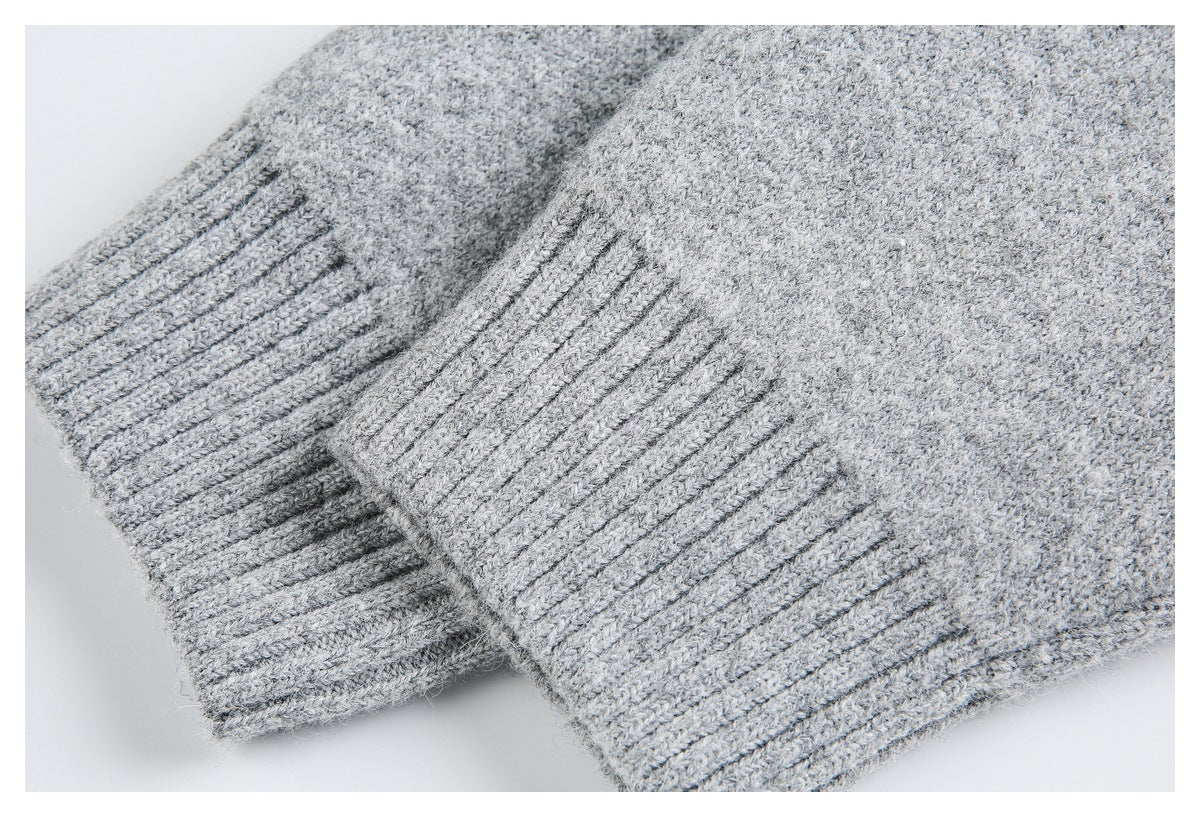 Close-up of two light gray ribbed knit cuffs or edges overlapping.