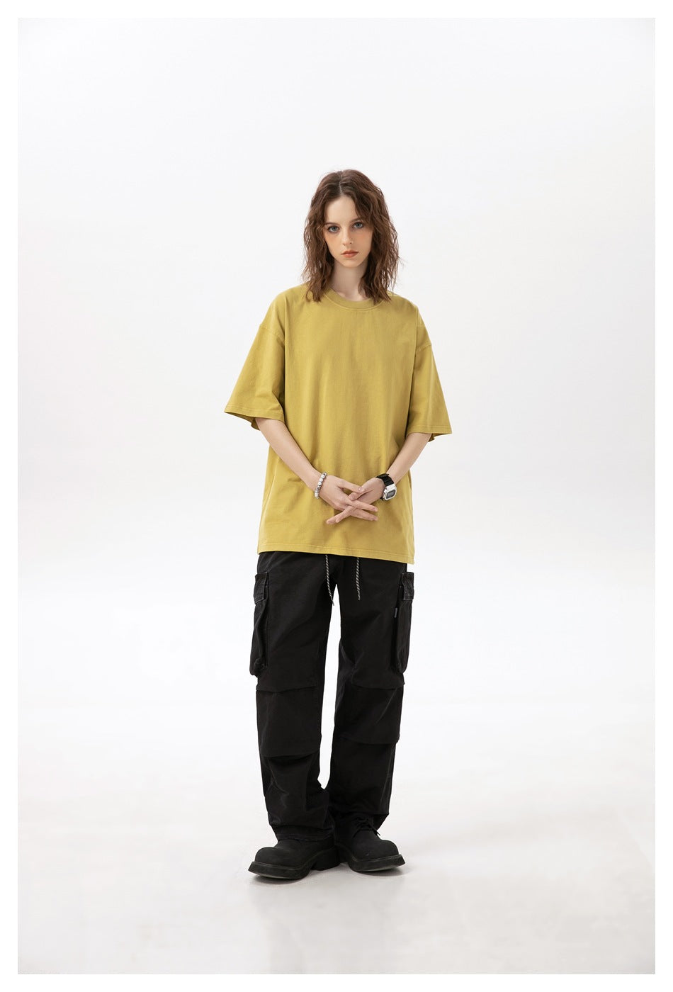 Model wearing an oversized mustard-yellow T-shirt with black cargo pants.