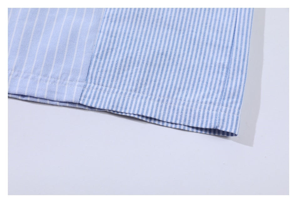Close-up of a light blue and white striped garment hem, with a section of finer blue stripes.